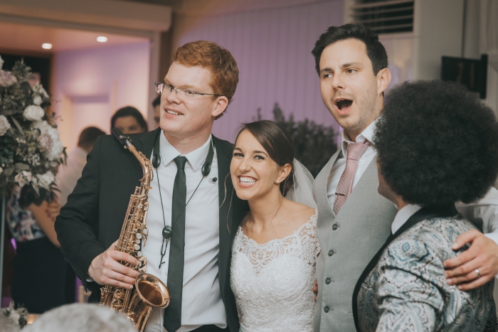 Bride and groom with saxophonist and lead singer